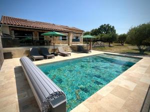 a swimming pool with lounge chairs and a house at Villa Opaline in Issirac