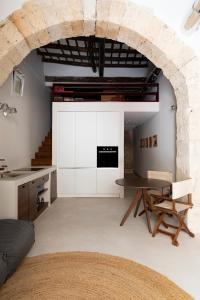 a living room with a table and a stone wall at Loft Serisso in Trapani +22 photos