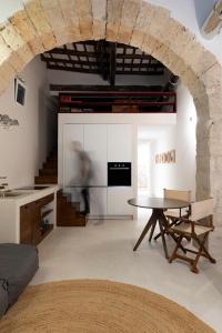 a living room with a table and a kitchen at Loft Serisso in Trapani