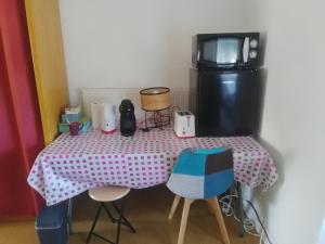 a pink and white table with chairs and a microwave at domdom72 in Connerré
