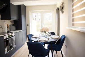 a kitchen and dining room with a table and chairs at Luxury 4-Bedroom Haven Garden Parking in South Norwood +11 photos