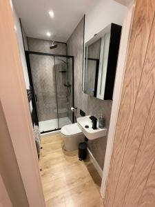 a bathroom with a white toilet and a sink at Luxury 4-Bedroom Haven Garden Parking in South Norwood