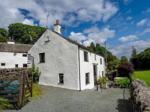 a white cottage with a gate and a fence at Pass the Keys Stunning 4 Bed Barn Conversion Hot Tub in Lake Side