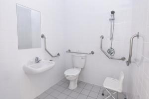 een witte badkamer met een toilet en een wastafel bij SUN1 Foreshore Cape Town in Kaapstad