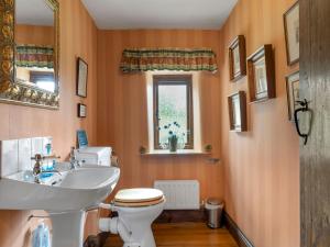 a bathroom with a sink and a toilet and a window at Pass the Keys Stunning 4 Bed Barn Conversion Hot Tub in Lake Side +34 photos