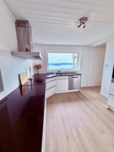 cocina con fregadero y ventana grande en Cherfull 2 bedrooms, en Oksval