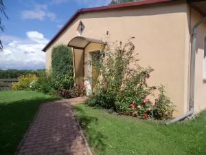 a brick path next to a building with flowers at Appartementhof Fastnacht am See in Leuengarten