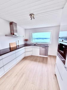 Una cocina blanca con fregadero y ventana. en Cherfull 2 bedrooms, en Oksval