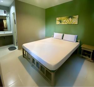 a large bed in a room with a green wall at Hope Pension House - Danao in Danao City