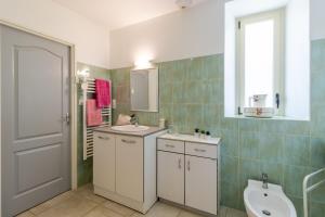 a bathroom with a sink and a toilet and a window at Belle Ferme Périgourdine in Sainte-Foy-de-Longas