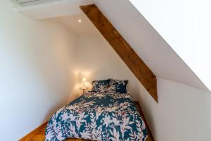 a bedroom with a bed with a blue and white bedspread at Belle Ferme Périgourdine in Sainte-Foy-de-Longas
