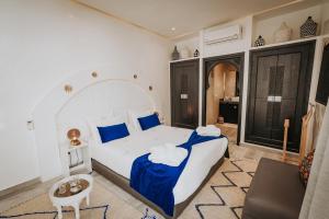 a bedroom with a large bed with blue pillows at RIAD NOLITA & SPA Kasbah in Marrakesh +71 photos