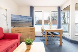 a living room with a red couch and a table at Haus Panorama Laboe Nr 1 in Laboe