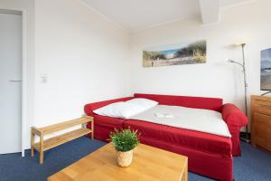 a living room with a red couch and a table at Haus Panorama Laboe Nr 1 in Laboe +30 photos