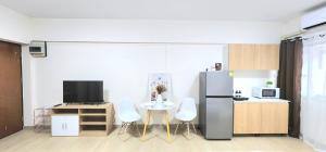a kitchen with a refrigerator and a table with chairs at New room DMKairport,BTS, impact 340 in Ban Song Hong