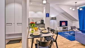 a kitchen and dining room with a table and chairs at Rezydencja Niechorze 306 z Widokiem na Morze - 5D Apartments in Niechorze