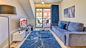 a living room with a couch and a tv at Rezydencja Niechorze 306 z Widokiem na Morze - 5D Apartments in Niechorze