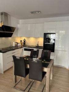 a kitchen with a table and chairs in a kitchen at Apartament Polanki E207 in Kołobrzeg
