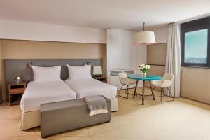 a hotel room with two beds and a table at Fraser Suites Paris La Défense in Courbevoie