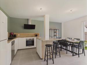 eine Küche mit Tisch und Hockern in einem Zimmer in der Unterkunft Jardin clos - Maison de plain-pied pour 4 in Le Tour-du-Parc