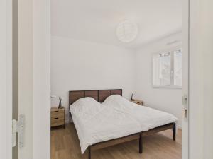 ein Schlafzimmer mit einem Bett mit weißen Laken in der Unterkunft Jardin clos - Maison de plain-pied pour 4 in Le Tour-du-Parc