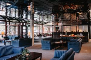 a lobby with blue couches and tables and windows at Bårdshaug Herregård in Orkanger