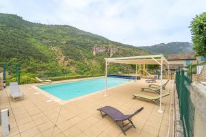 a swimming pool with chairs and a canopy at Gîte Logement 2/4 personnes - Village de gites des Vignes in Les Vignes