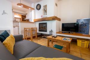 a living room with a couch and a tv at Gîte Logement 2/4 personnes - Village de gites des Vignes in Les Vignes