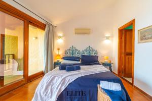 una camera da letto con un letto con lenzuola blu e una finestra di Villa sul Golfo del Pevero con accesso a mare a Porto Cervo Altre 50 foto