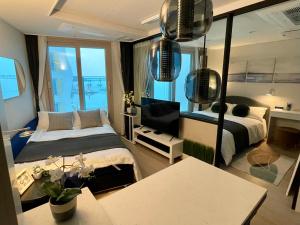 釜山にあるOcean Front Apartmentのベッドルーム1室(ベッド1台、鏡、テーブル付)