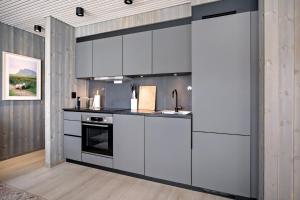 una cucina con mobili bianchi e una stufa di Moderne leilighet ved sjøen med opptil åtte sengeplasser a Henningsvær