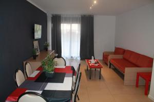 a living room with a red couch and a table at Piso SolyMar TRIMAR in Lloret de Mar