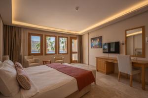 una camera d'albergo con un letto, una scrivania e una televisione di Loryma Luxury Hotel Bozburun a Bozburun
