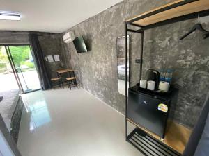 a room with a kitchen with a refrigerator and a table at บ้านสวนวงศ์จินดารักษ์ in Phayao