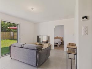 ein Wohnzimmer mit Sofa und Fernseher in der Unterkunft Jardin clos - Maison de plain-pied pour 4 in Le Tour-du-Parc