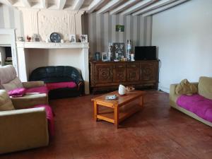 a living room with two couches and a coffee table at Ferme Beauchêne in Laigné-en-Belin +2 photos