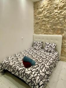 a bedroom with a bed with a stone wall at Centre - Climatisation - Calme - Cuisine - Wifi - Tramway in Nice