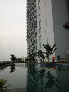a building and a swimming pool in front of a building at Alpine Room at TreePark City Apartement in Tangerang