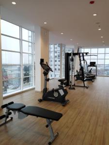 a gym with treadmills and exercise equipment in a building at Alpine Room at TreePark City Apartement in Tangerang