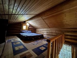 ein Dachzimmer mit Bett in einer Blockhütte in der Unterkunft Hotel Doi Haiduci in Orhei + 104 Fotos