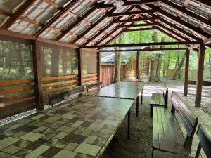a long wooden table in a pavilion with benches at Hotel Doi Haiduci in Orhei