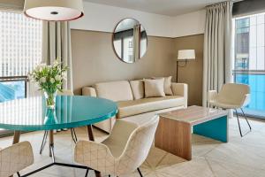 a living room with a couch and a table at Fraser Suites Paris La Défense in Courbevoie