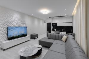 a living room with a couch and a flat screen tv at Eron Villas Velipoje in Velipojë