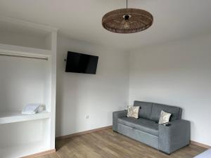 a living room with a couch and a flat screen tv at Majesty Charming in Horta