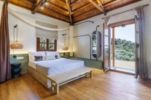 a bedroom with a bed and a bench in front of a window at Petrino Villas in Skopelos Town +277 photos
