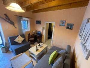 a living room with a couch and a table at The Great Balcony in Ioulis +35 photos