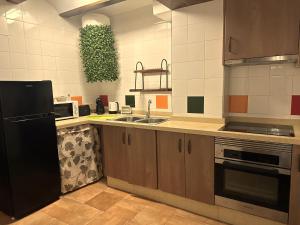 a kitchen with a black refrigerator and a sink at El Refugio de Casa Nieves in Villahermosa del Río