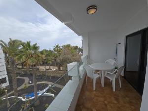 a balcony with a table and chairs and a pool at Costa Luz BL 4 6 in Puerto del Carmen