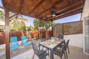 d'une terrasse avec une table, des chaises et un ventilateur de plafond. dans l'établissement Laranca Oneiro Seaside Villa, à Perivólia