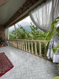 balcón con ventana y vistas a los árboles en Heaven apartment, en Gabala